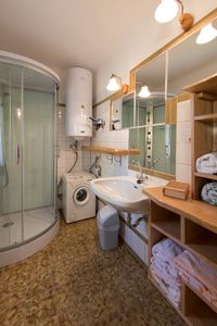 Blick ins Bad von der Tür aus mit Duschkabine, Waschmaschine und Waschbereich
